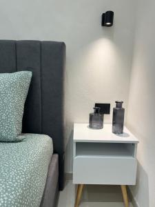 a bed with a night stand next to a side table at Sofia e Clara Mozia in Marsala