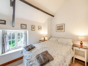 a bedroom with a bed and a window at Stable Cottage - 26032 in Wark