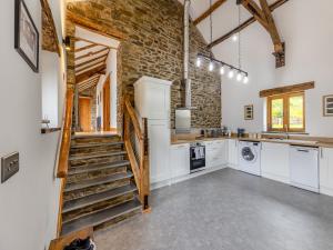 a kitchen with a staircase and a brick wall at Ty Carreg in Llanbadarn-fawr +17 photos