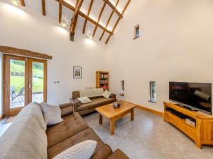 a living room with a couch and a tv at Ty Carreg in Llanbadarn-fawr