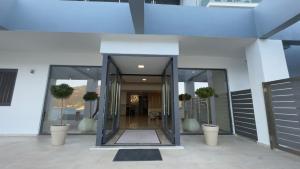 an entrance to a building with glass doors and potted plants at Ponti Beach Hotel in Vasiliki