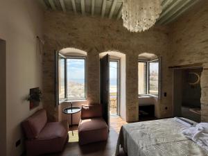 a bedroom with a bed and two chairs and a chandelier at Nymfea Ano Syros in Ano Syros