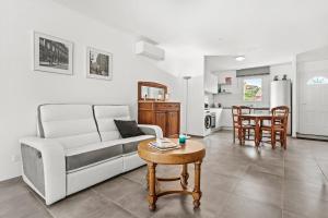 a living room with a couch and a table at Villa les coteaux du soleil in Carcès