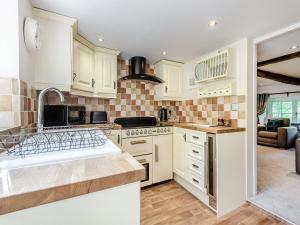 a kitchen with white cabinets and a stove top oven at Townhead Cottage in Newbiggin