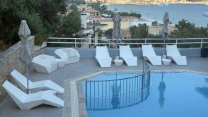 a patio with white chairs and a swimming pool at Ponti Beach Hotel in Vasiliki