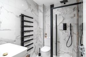 a bathroom with a shower and a toilet and a sink at Modern Apartments Romford near Elizabeth Line in Romford