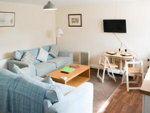a living room with a couch and a table at Cygnet Cottage - Uk43546 in Belford