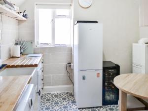 a white refrigerator in a kitchen with a table at Ashlors in Bridlington