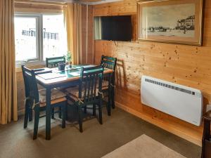 a dining room with a table and chairs and a television at Algwen Cabin in West Walton