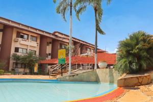 einen Pool vor einem Hotel mit Palmen in der Unterkunft Recanto das Águas Quentes - TURISMO in Rio Quente