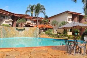 ein Resort mit einem Swimmingpool mit Tisch und Sonnenschirm in der Unterkunft Recanto das Águas Quentes - TURISMO in Rio Quente