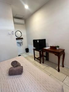 a bedroom with a desk and a bed and a table at Simon Homestay in Sanur