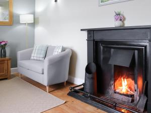 ein Wohnzimmer mit einem Kamin und einer weißen Couch in der Unterkunft Rhiw Farmhouse in Llangelynin