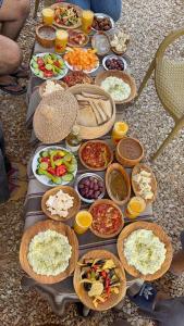 un tavolo apparecchiato con tanti tipi diversi di cibo di Siwa Gardenia Cottage اكواخ سيوة جاردينيا a Siwa