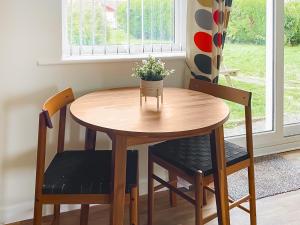 a wooden table and chairs in a room with a window at Barn Owls Holiday Bungalow in Salcombe Regis +7 photos