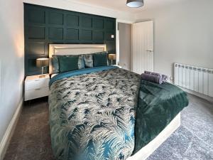 a bedroom with a large bed with a green headboard at Prospect Cottage in Catton +9 photos