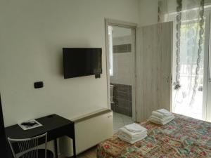 a bedroom with a bed and a desk and a television at Hotel Paradise in Bruzolo