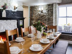 einen Holztisch mit Tellern und Weingläsern in der Unterkunft Rhiw Farmhouse in Llangelynin