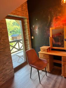 una scrivania e una sedia in una stanza con una finestra di Źródło Chillu - Dom wakacyjny nad jeziorem a Pólczno Altre 6 foto