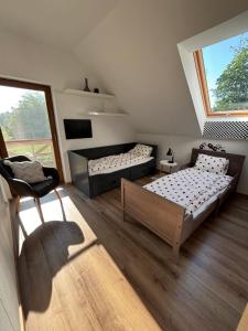 una camera da letto con due letti e una finestra di Źródło Chillu - Dom wakacyjny nad jeziorem a Pólczno