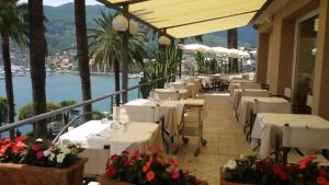 a restaurant with white tables and flowers on a balcony at Hotel Continental in Santa Margherita Ligure