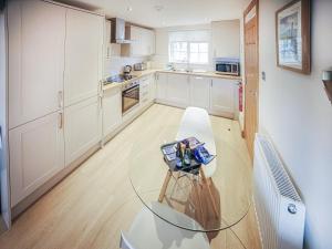 a kitchen with white cabinets and a glass table at Borrowdale View - Uk45176 in Threlkeld