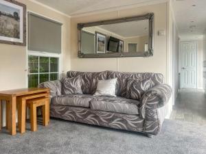 a living room with a couch and a mirror at Meadows Farm Lodge - Uk47614 in Gorseinon