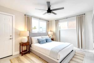 a white bedroom with a bed and a ceiling fan at Brilliance-Fire Pit & Foosball-Middle of Old Town in Scottsdale