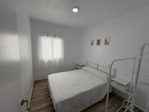 a white bedroom with a bed and a window at Casa Nova de Bolonia in Bolonia