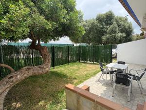 a patio with a table and chairs and a tree at Casa Nova de Bolonia in Bolonia