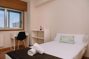 um quarto com uma cama, uma escrivaninha e uma janela em Tranquilidad con vistas de Vigo by CABANA Rentals em Vigo