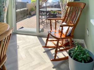 une chaise à bascule et une plante en pot dans une pièce dans l'établissement Covina - Uk43994, à Anderby