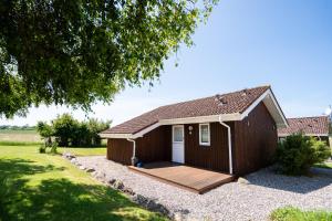 ノイシュタット・イン・ホルシュタインにあるObjekte im Umland Hof Ruhleben Haus Muschelsucherの木製のデッキのある小さな小屋