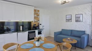 Una sala de estar con un sofá azul y una mesa. en Byala Cliff Sea View Suite, en Byala