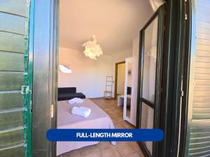 Una pequeña habitación con una cama y un espejo. en Yranim 1 - AFFITTICA, en Pantelleria