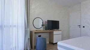 1 dormitorio con escritorio, ordenador y espejo en Byala Cliff Sea View Suite, en Byala