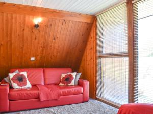 KingsdownにあるPoppy Lodgeの木製の壁の部屋の赤いソファ