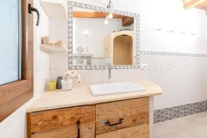 une salle de bain avec un lavabo et un miroir dans l'établissement White Cottage, à Olbia 42 autres photos