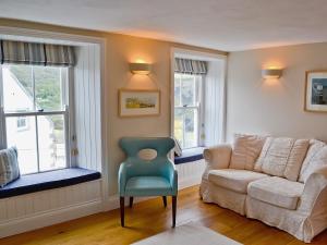 una sala de estar con un sofá y una silla en Mainbrace, en Port Isaac