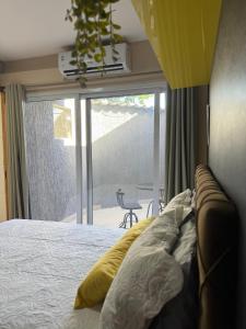 a bedroom with a bed and a view of a patio at Casamar Lofts, Praia dos Anjos Arraial do Cabo in Arraial do Cabo