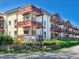 an apartment building with balconies on the side of a street at Düneneck 09 in Zempin