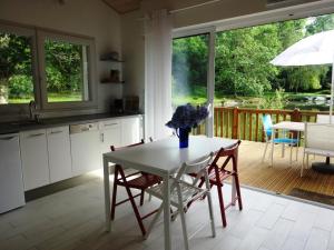 een keuken en eetkamer met een tafel en stoelen bij Chalet " Côté Lac " in Castets