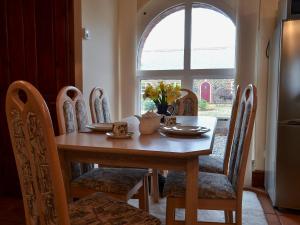 a dining room table and chairs with a table and a window at The Nook in Clovelly