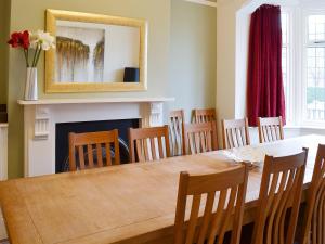 Un comedor con mesa y sillas y chimenea. en Bay House, en Filey