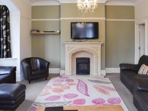 Una sala de estar con chimenea y un televisor encima. en Bay House, en Filey