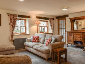 een woonkamer met een bank en een tafel bij Beck Foot Cottage in Sedbergh