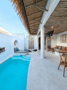 an infinity pool in a villa with a living room at Villa Chioni Uluwatu by LODGELINK BALI in Uluwatu