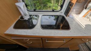 a rear view mirror of an rv with a window at Henneby Camping - V179 in Henne Strand