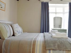 a bedroom with a bed with towels on it at Cobblestones in Whitby +13 photos