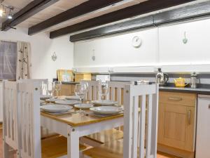 a kitchen with a table with plates and wine glasses at Cobblestones in Whitby